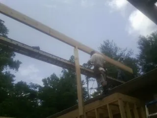 Carpenter setting a ridge beam over a new addition frame — Ice Dam Removal by Roofing Brothers in Mechanicstown