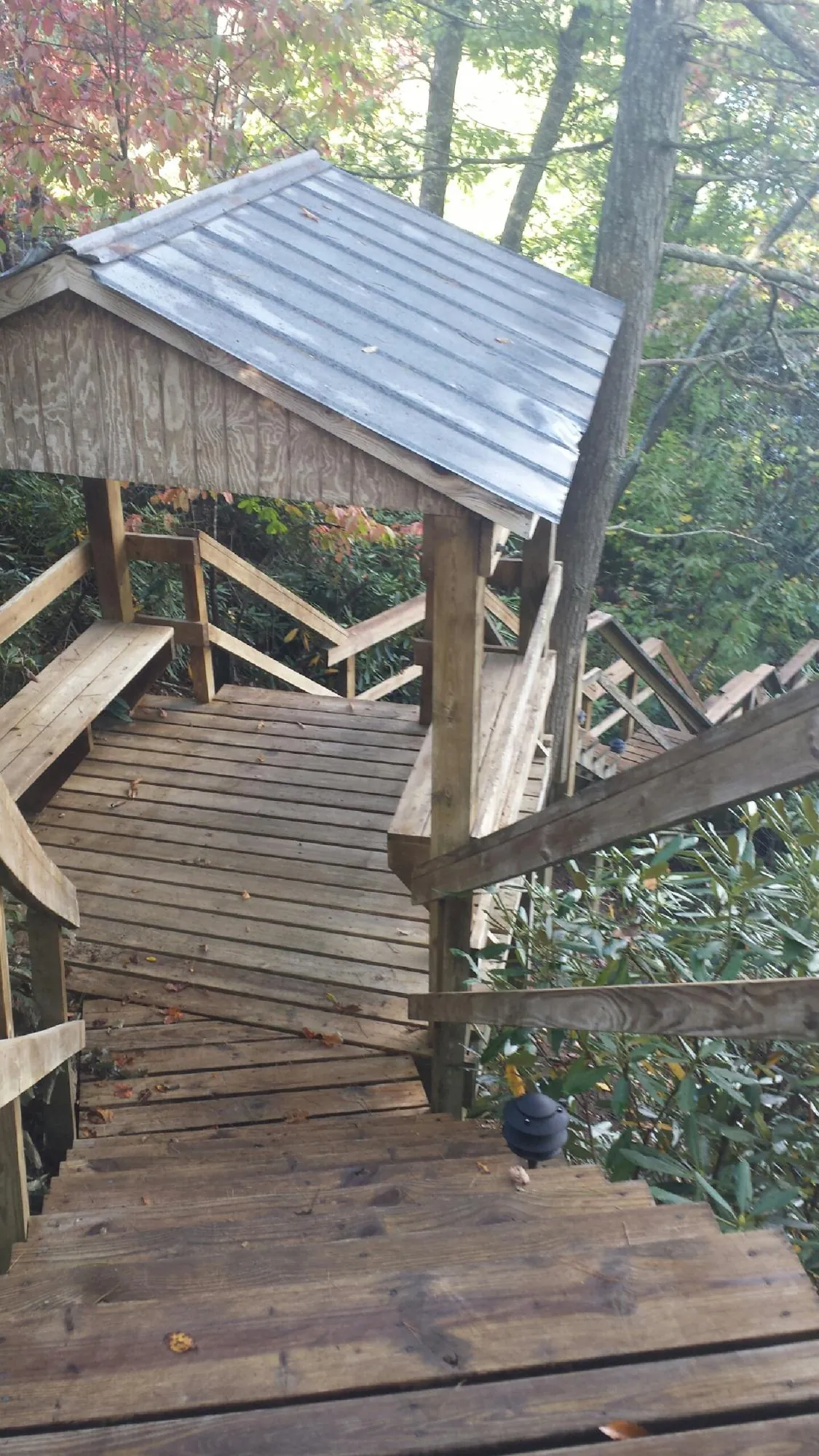 Metal roofed shelter over wooden steps on a wooded walkway — Skylight Repair & Installation work by our crew in Mechanicstown